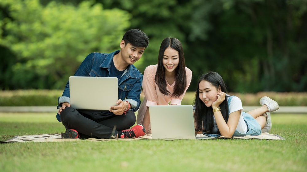 学生在电脑前查看浙师大网上办事大厅的证明申请页面，桌面上放着一份待核对的纸质证明材料